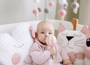 Bebe dans un berceau avec les couleurs blanc et rose