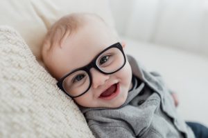 Nourrisson avec des lunettes de vue souriant a l'objectif