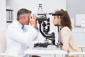 Jeune fille aux cheveux bouclés entreprenant un examen des yeux
