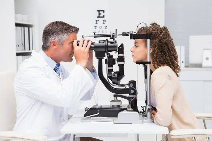 Jeune fille aux cheveux bouclés entreprenant un examen des yeux