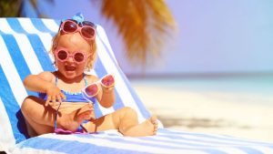 Petite fille blonde avec plusieurs paires de lunettes