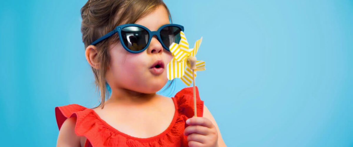 Petite fille au lunettes de soleil design au montures bleu